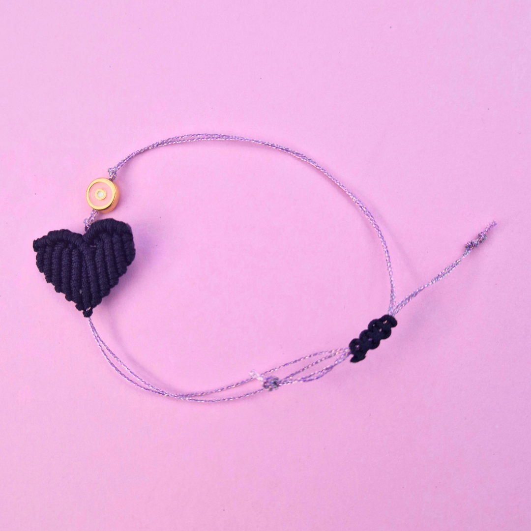 Χειροποίητο Μακραμέ Βραχιόλι με Διαγώνια Μαύρη Καρδιά, Ζάμακ Στοιχείο Στρογγυλό Μάτι και Μεταλιζέ Λιλά Κλωστή